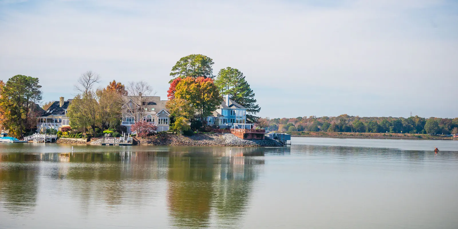 Houses and autumn trees along a calm lake shore
